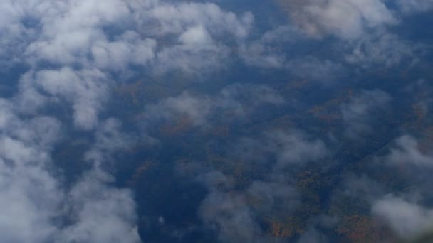 La vista da un aereo volante a terra attraverso nuvole bianche. copia spazio — Video Stock