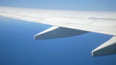 Bulutların ve gökyüzünün arka planına karşı havada bir uçak kanadı. Boşluğu kopyala