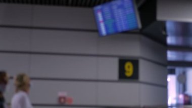 Arka plan bulanık. Havaalanı terminalinde tıbbi maske takan insanlar.