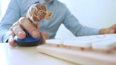 Bandajlı parmaklı bir adamın eli bilgisayar faresi ve klavye kullanıyor.