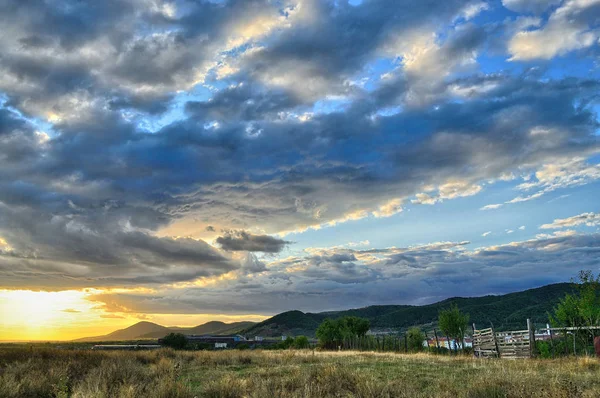 Intense zonsondergang met enorme wolken die de hemel bedekken — Stockfoto