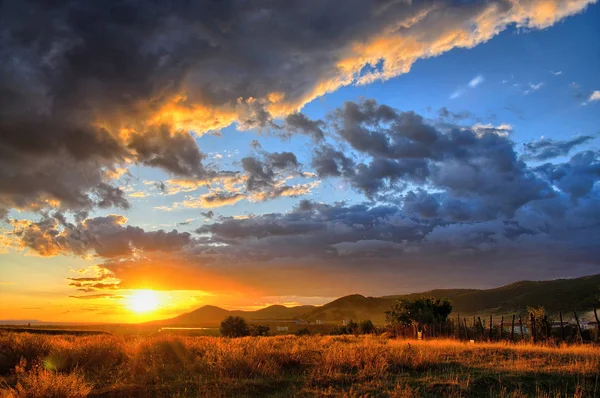 Pôr-do-sol intenso com nuvens maciças cobrindo o céu — Fotografia de Stock