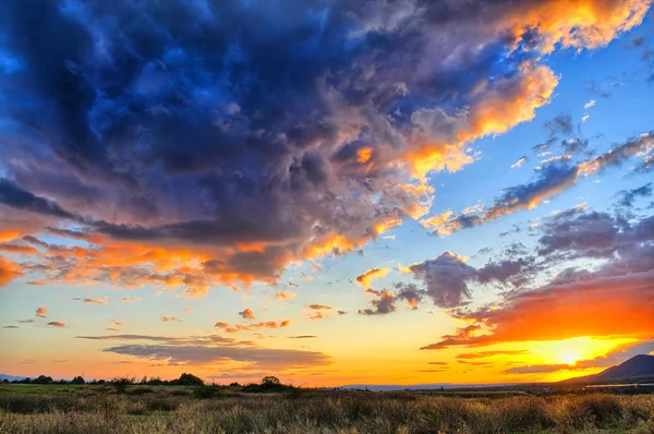 Intensiver Sonnenuntergang mit massiven Wolken, die den Himmel bedecken — Stockfoto