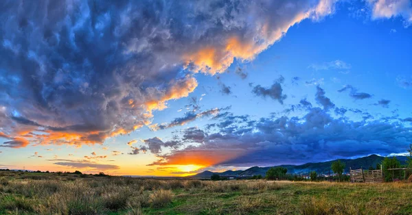 Pôr-do-sol intenso com nuvens maciças cobrindo o céu — Fotografia de Stock