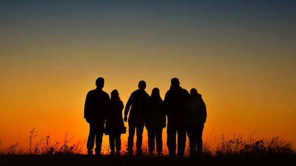Three families silhouette gathering for a photo at sunset — Stock Photo, Image