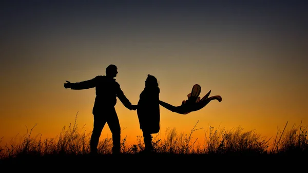 Пара силуэтов, держащихся за руки на закате — стоковое фото