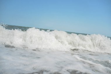 Gün boyunca deniz dalgaları ve küçük damlalar sahile düşer.