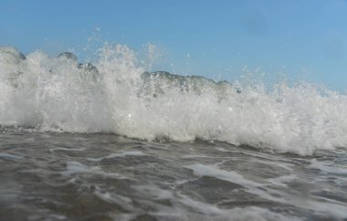 Gün boyunca deniz dalgaları ve küçük damlalar sahile düşer.