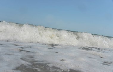 Gün boyunca deniz dalgaları ve küçük damlalar sahile düşer.