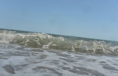 Gün boyunca deniz dalgaları ve küçük damlalar sahile düşer.