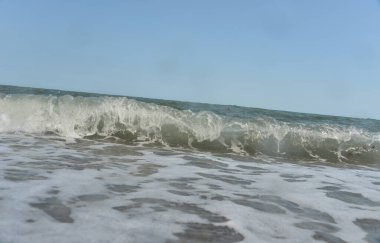 Gün boyunca deniz dalgaları ve küçük damlalar sahile düşer.