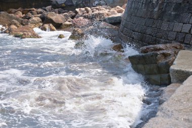 Gün boyunca deniz dalgaları ve küçük damlalar sahile düşer.
