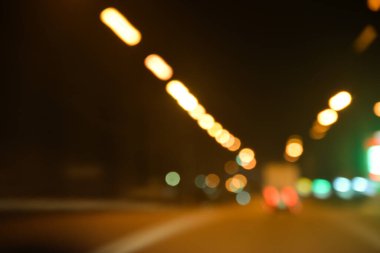 Arabaların farları ve sokak lambalarının ışıkları karanlıkta renkli bir iz çiziyor.