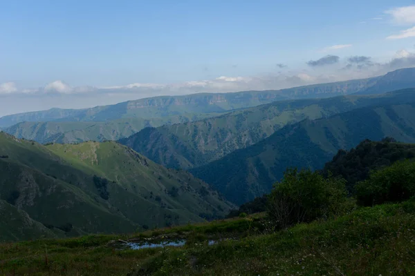 Yol yatağı düzensiz, sarmal, dağların ve kayalıkların arasından geçiyor. Bulutlar karanlık, alçak ve yağmurlu. Yol boyunca yoğun beyaz bir sis yayılıyor..