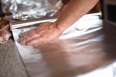 Bir sonbahar günü evdeki ızgarada kendi ellerinle folyoya sarılı et pişirme süreci.