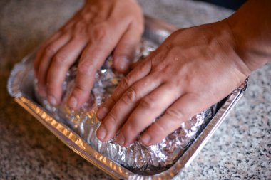 Bir sonbahar günü evdeki ızgarada kendi ellerinle folyoya sarılı et pişirme süreci.