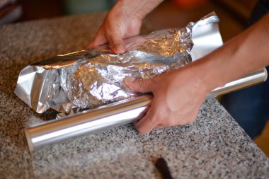 Bir sonbahar günü evdeki ızgarada kendi ellerinle folyoya sarılı et pişirme süreci.