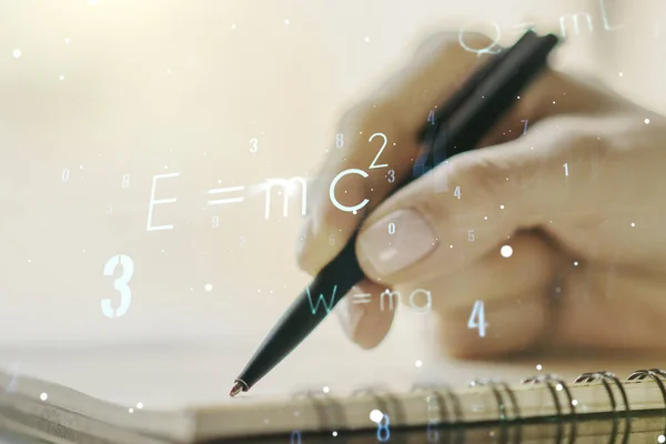 Creative scientific formula hologram with woman hand writing in notepad on background, research concept. Multiexposure