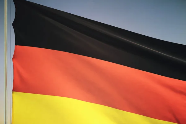 Duitsland vlag op zonsondergang hemel achtergrond, close up — Stockfoto