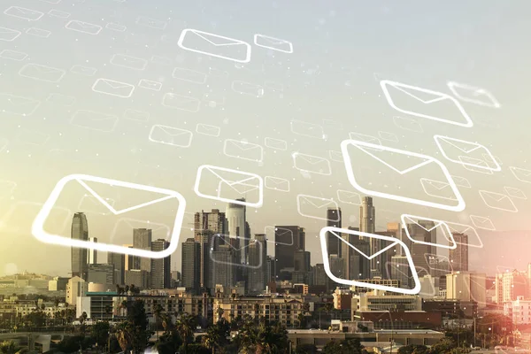 ロサンゼルス市の高層ビルの背景に抽象的な仮想郵便封筒ホログラムの二重暴露。電子メールとスパムの概念 — ストック写真