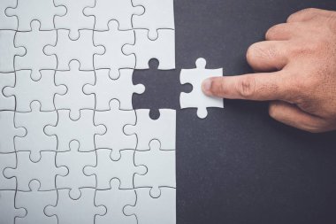 Bağlantı kavramı: yapboz parçalarını tutan el ve sokmak eksik delik