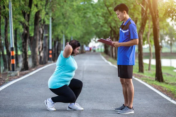 Asya adam parkta scot atlama yaparken şişman kadın önünde kağıt yazma