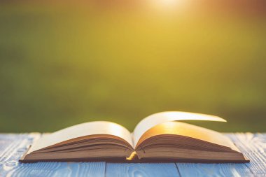 Kitap soyut bulanıklık ve bokeh ile ahşap tabloda gündoğumu veya günbatımı zamanı kapatın