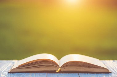 Kitap soyut bulanıklık ve bokeh ile ahşap tabloda gündoğumu veya günbatımı zamanı kapatın