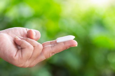 Fitil mum yeşil doğa ışık tutan el yakından arka plan bulanıklık. Hemoroid kavramı tedavisinde