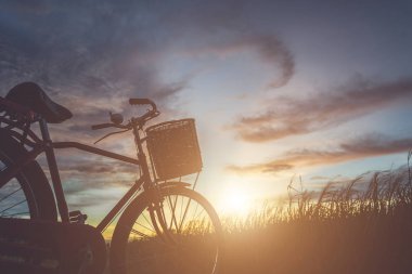 Japonya tarzı klasik Bisiklet günbatımı zamanı alanında, silüeti