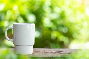 Beyaz Seramik kahve fincanı ahşap masa veya yeşil doğa ışık olan sayaç görüntü arka plan ve metin, tasarım, Fotoğraf montaj veya reklam için yer