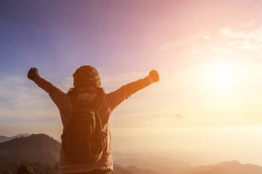 Kadın kaldırdı elleriyle başarılı duygu kavramı bir dağın tepesinde duran sırt çantası ile