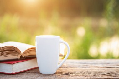 Kahve ve Bahçe kavramı: fincan kahve, kitap ve sabah zamanında güneş ışığı ile ahşap masa üzerinde Bahçe Ekipmanları