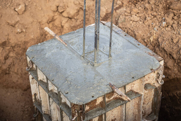 Pouring concrete into steel box for foundation pillar in process