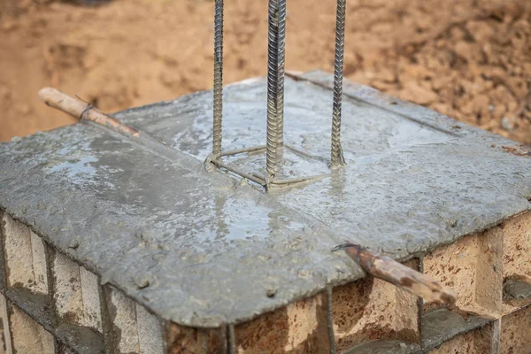 Pouring concrete into steel box for foundation pillar in process