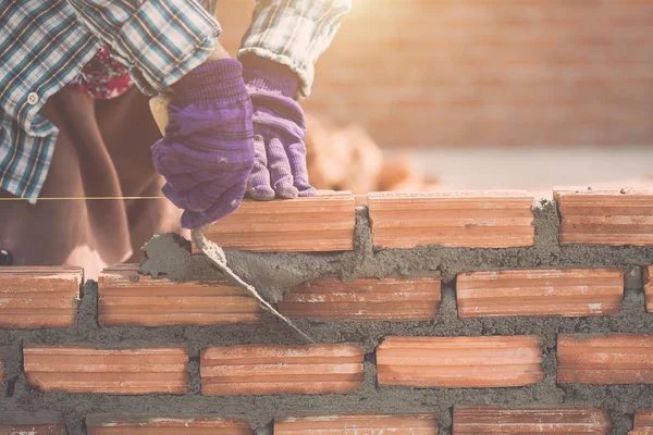 Trabajador instalación de ladrillos de pared en proceso de construcción de viviendas —  Fotos de Stock
