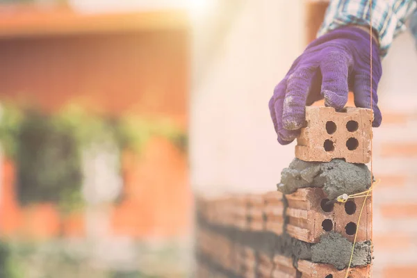 Trabajador instalación de ladrillos de pared en proceso de construcción de viviendas —  Fotos de Stock