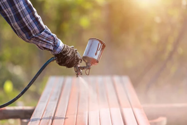 Arbeiter sprüht Farbe auf Stahlrohr, um den Rost auf dem Stahlrohr zu verhindern — Stockfoto