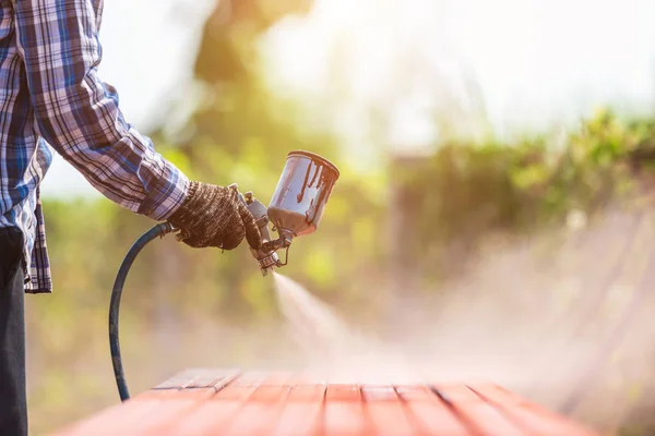 Arbeiter sprüht Farbe auf Stahlrohr, um den Rost auf dem Stahlrohr zu verhindern — Stockfoto