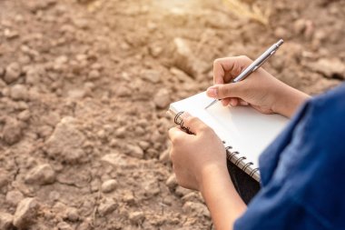 Asyalı öğrenci araştırma yapıyor veya boş arazikuru toprak kontrol 