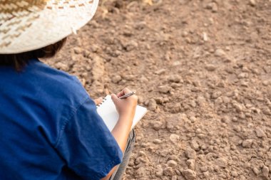 Asyalı öğrenci araştırma yapıyor veya boş arazikuru toprak kontrol 