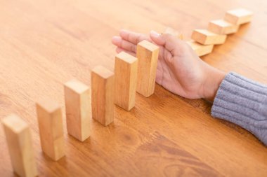El dur ahşap blok. Domino risk etkisi kavramı 
