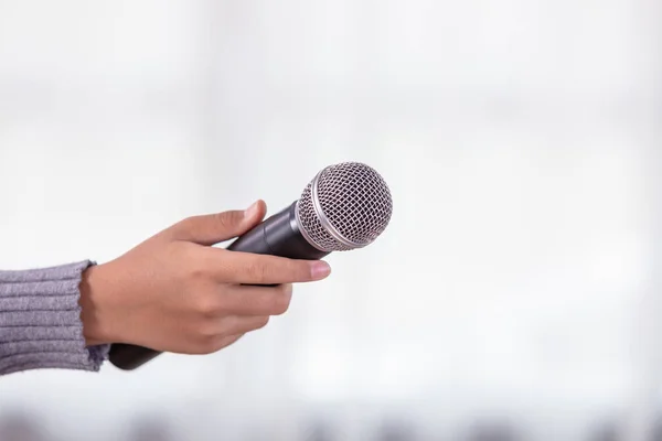 Main de journaliste tenant un nouveau microphone noir — Photo