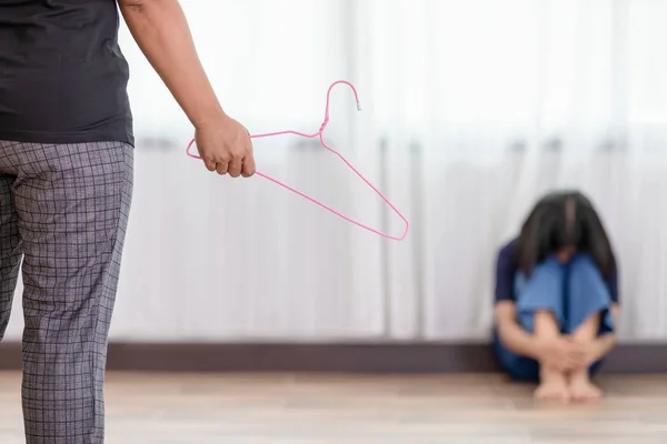 Madre castigando a su hija. Mujer sosteniendo percha de ropa — Foto de Stock