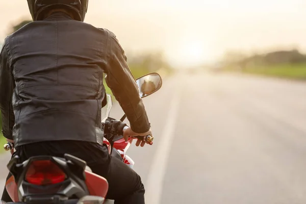 Bonito motociclista desgaste jaqueta de couro e segurando capacete em — Fotografia de Stock