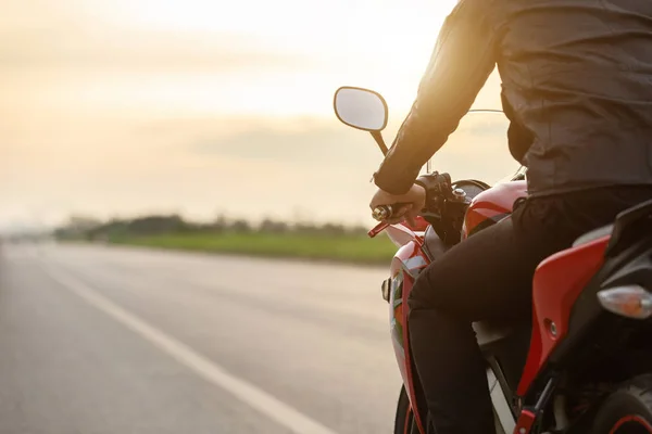 Schöner Motorradfahrer trägt Lederjacke und sitzendes Motorrad — Stockfoto