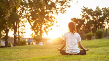 Güzel Asyalı kadın parkta yoga egzersizi yapıyor.