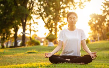 Güzel Asyalı kadın parkta yoga egzersizi yapıyor.