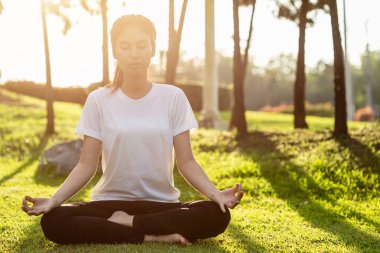 Güzel Asyalı kadın parkta yoga egzersizi yapıyor.