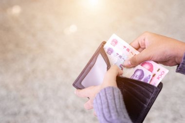 Siyah duvardaki banknotları sayan ya da kontrol eden Asyalı genç turist